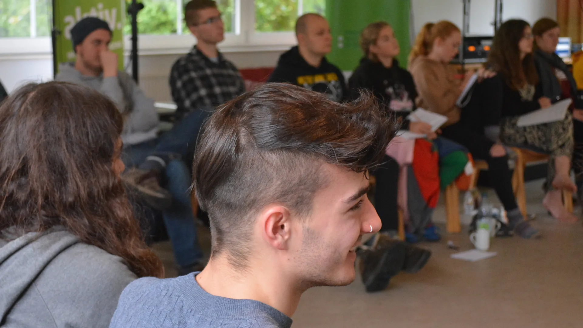Junge Menschen auf Stühlen diskutieren 